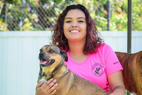 Paw Commons employee holding a dog on her lap