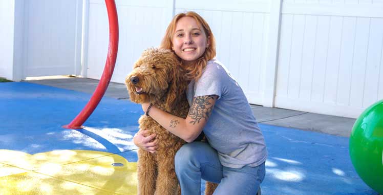 Woman hugging a dog in the outdoor space